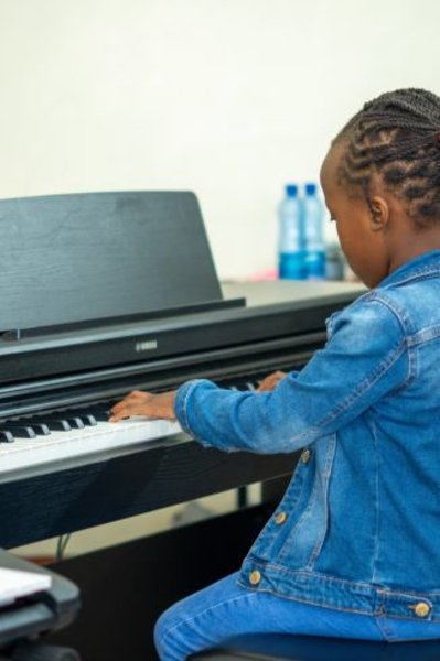 Music student taking piano lessons at home in Nairobi
