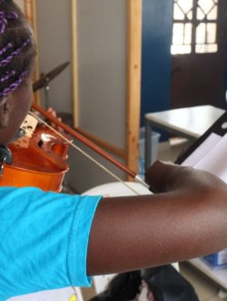 Child learning guitar with Cheza Music School teacher